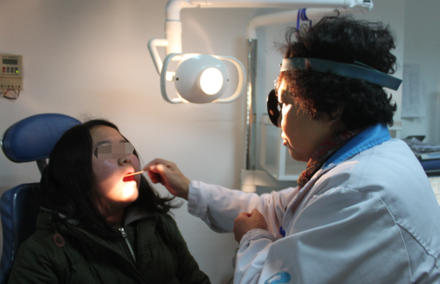 李醫生為慢性咽炎患者做檢查